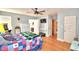 Comfortable bedroom features hardwood floors, a ceiling fan, television, and quirky arcade game at 301 S Clinch Lake Blvd, Frostproof, FL 33843