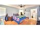 A well-lit bedroom featuring hardwood floors, a ceiling fan, arcade game, and ensuite bathroom at 301 S Clinch Lake Blvd, Frostproof, FL 33843