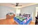 Well-lit bedroom featuring a ceiling fan, hardwood floors, and comfortable furniture at 301 S Clinch Lake Blvd, Frostproof, FL 33843