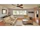 Cozy living room featuring neutral-toned seating, ceiling fans, and a bright window with lake views at 301 S Clinch Lake Blvd, Frostproof, FL 33843