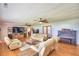 Spacious living room with ceiling fans, a piano, hardwood floors, and comfy seating at 301 S Clinch Lake Blvd, Frostproof, FL 33843
