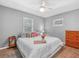 Bright bedroom featuring a plush white comforter, ceiling fan, and warm wood-look flooring at 3123 Mar Lisa Cove Rd, Lake Wales, FL 33898