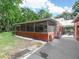 Back exterior featuring a screened-in porch, two motorcycles and lush greenery at 3123 Mar Lisa Cove Rd, Lake Wales, FL 33898