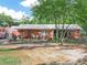 A quaint single-story brick home with metal roof and comfortable front porch sitting area at 3123 Mar Lisa Cove Rd, Lake Wales, FL 33898