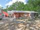 A single-story brick home with a metal roof, front porch sitting area, and an adjacent two-car garage at 3123 Mar Lisa Cove Rd, Lake Wales, FL 33898