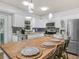 A bright kitchen featuring white cabinets, stainless steel appliances, and a butcher block island with seating at 3123 Mar Lisa Cove Rd, Lake Wales, FL 33898