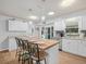 Updated kitchen boasts white cabinets, butcher block island with seating, and stainless steel appliances at 3123 Mar Lisa Cove Rd, Lake Wales, FL 33898
