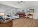 A well-lit living room featuring wood floors, a brick fireplace and white sofa with blue accent pillows at 3123 Mar Lisa Cove Rd, Lake Wales, FL 33898