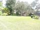 Large backyard featuring mature trees, a well-maintained lawn, and a storage shed at 3567 Red Oak Ct, Lake Wales, FL 33898