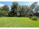 Beautiful backyard with mature trees and grassy areas at 3567 Red Oak Ct, Lake Wales, FL 33898