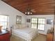Bedroom with wood ceiling, ceiling fan, two windows, and neutral walls with artwork at 3567 Red Oak Ct, Lake Wales, FL 33898