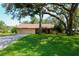 Well-maintained single-story home with green lawn and mature trees at 3567 Red Oak Ct, Lake Wales, FL 33898