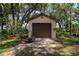 Garage and driveway surrounded by trees and grass at 3567 Red Oak Ct, Lake Wales, FL 33898