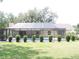 Backyard showcasing a screened-in pool, trimmed hedges, and a spacious lawn for outdoor activities at 3567 Red Oak Ct, Lake Wales, FL 33898