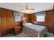 Bedroom featuring a plaid bedspread, wood paneling, and carpet at 450 Westfall Dr, Kenansville, FL 34739