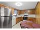 Traditional eat-in kitchen featuring wood cabinets, white appliances, and tile flooring at 450 Westfall Dr, Kenansville, FL 34739