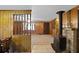 Living room featuring wood paneling, carpet, wood-burning stove, and open staircase at 450 Westfall Dr, Kenansville, FL 34739