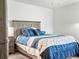 Close-up of the bed in a bedroom with a wooden headboard and blue bedding at 4833 Drake Ave, Lakeland, FL 33811