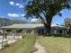 Exterior view of the condominium with a large tree in the front yard and pool at 711 Springer Dr # 9, Lake Wales, FL 33853