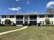 Well-maintained condominium building with manicured lawn and walkway at 711 Springer Dr # 9, Lake Wales, FL 33853