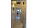 Well-lit hallway with tile floors, wall sconces, and access to various rooms in the home at 711 Springer Dr # 9, Lake Wales, FL 33853