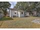 A partial view of the home's backyard features mature trees and a grassy area at 720 S Orange Ave, Bartow, FL 33830