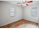 Comfortable bedroom with wood floors, a ceiling fan, and two windows at 720 S Orange Ave, Bartow, FL 33830