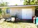 A storage shed featuring double doors, a window, and surrounded by lush greenery at 9 Silver Sand Rd, Frostproof, FL 33843