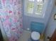 Bathroom featuring a toilet, window, and a shower with floral curtain at 9 Silver Sand Rd, Frostproof, FL 33843