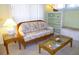 Cozy living area with wicker sofa, glass coffee table, side table, and shelving unit at 9 Silver Sand Rd, Frostproof, FL 33843