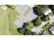 Bird's-eye view of a community featuring tennis courts and adjacent residential homes in a green surrounding at 1077 Medinah Way, Winter Haven, FL 33884