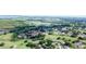 Scenic aerial view showcasing a community with homes nestled among trees and a golf course, with a lake in the distance at 1077 Medinah Way, Winter Haven, FL 33884