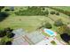Aerial view featuring tennis courts, swimming pool and manicured golf course in residential community at 1077 Medinah Way, Winter Haven, FL 33884
