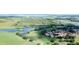 A beautiful aerial view of the community with golf course, pond, and verdant greenery at 1077 Medinah Way, Winter Haven, FL 33884
