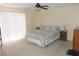 Comfortable bedroom with ceiling fan, slider, and carpeted floor at 1077 Medinah Way, Winter Haven, FL 33884