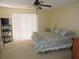 Bright bedroom featuring a ceiling fan, sliding doors, and a view of the outside at 1077 Medinah Way, Winter Haven, FL 33884