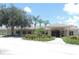 Front view of a clubhouse with well-maintained landscaping and a covered entrance walkway at 1077 Medinah Way, Winter Haven, FL 33884