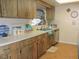 Practical kitchen featuring wood cabinets, tile flooring, and plenty of counter space at 1077 Medinah Way, Winter Haven, FL 33884
