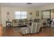 Inviting living room featuring neutral tones, tile flooring, and access to an outdoor area at 1077 Medinah Way, Winter Haven, FL 33884