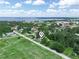 Panoramic aerial shot featuring a quaint neighborhood near a tranquil lake under a bright, partly cloudy sky at 111 D St, Frostproof, FL 33843
