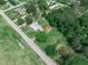 Aerial shot of a cozy home with a white roof, accented by lush landscaping and a paved driveway at 111 D St, Frostproof, FL 33843