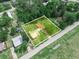 Expansive aerial view of a property featuring two structures and a lush green yard surrounded by mature trees at 111 D St, Frostproof, FL 33843