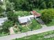 Aerial view of a home with a cozy front porch, surrounded by lush trees, and a well-maintained street at 111 D St, Frostproof, FL 33843