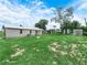 Spacious backyard boasts mature trees, shed, and a mix of grass and sandy areas at 111 D St, Frostproof, FL 33843