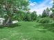 Lush backyard with healthy green grass and mature trees under a sunny sky at 111 D St, Frostproof, FL 33843