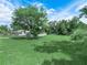 Large, grassy backyard featuring a mature tree and a well-maintained lawn at 111 D St, Frostproof, FL 33843