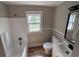 Bright bathroom with tub, toilet, window, modern vanity, and light fixtures at 111 D St, Frostproof, FL 33843