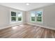 Bright bedroom featuring wood-look floors and ample natural light from two large windows at 111 D St, Frostproof, FL 33843