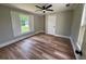 Bedroom with wood-look floors, ceiling fan, a window and white trim at 111 D St, Frostproof, FL 33843