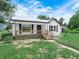 Home has front porch and is framed by a lush green lawn, garage in back at 111 D St, Frostproof, FL 33843